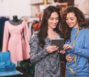 Two young designers work together using a tablet.